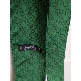 Photo of Vintage Hermès 100% Silk Men's Yellow Tie With Geometric Chain-Link Pattern.Hermès necktie reveals a distinctive interlocking novelty geometric print. This specific 1990s vintage model is the Hermès Kelly Green Equestrian Stirrup Print tie (Serial: 5202