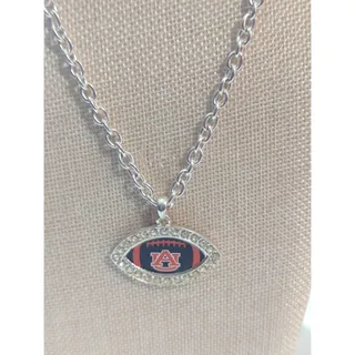 Photo of AU football shaped necklace. Silver necklace with rhinestones shaped like a football orange and blue. Necklace on silver chain.